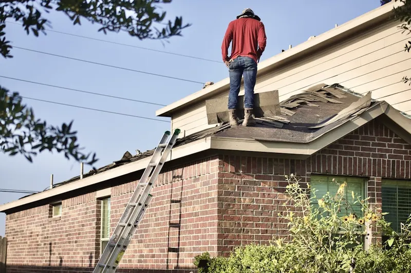 Professional roofer working on a residential roof in Highland-Stoner Hill
